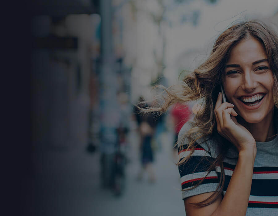 woman smiling whilst on mobile