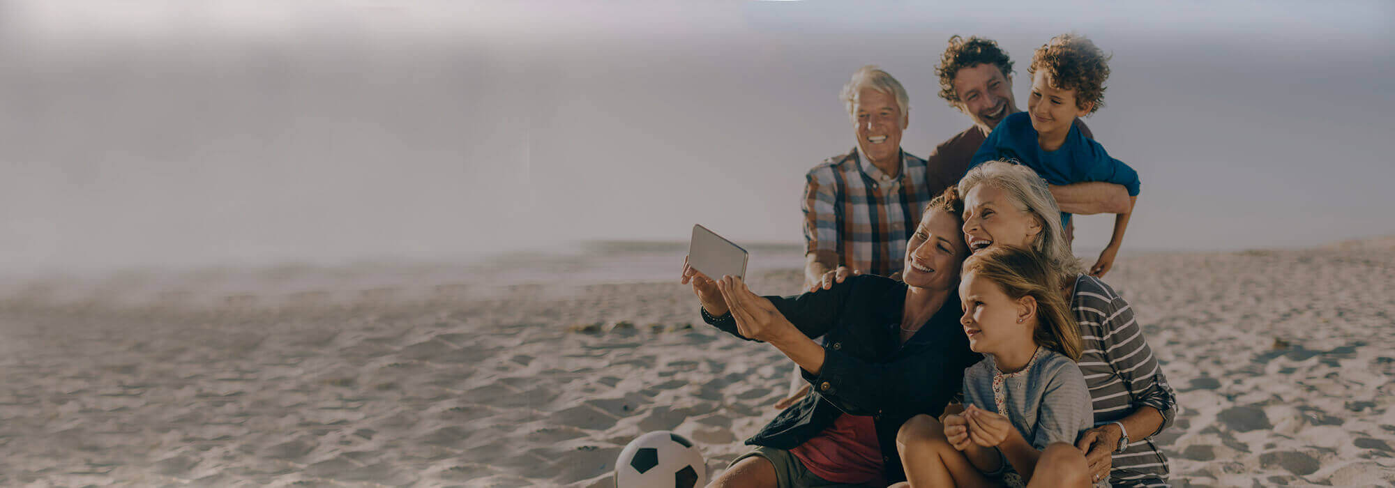 family taking picture at the beach
